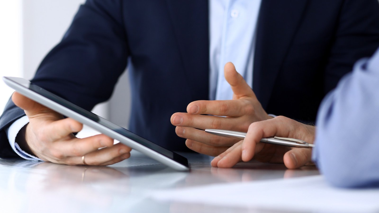 Bewirbdich.ch: Job-Coaching hilft in vielen Berufs- und Lebenslagen. Hände mit Tablet und Stift im Beratungsgespräch – Jobcoaching