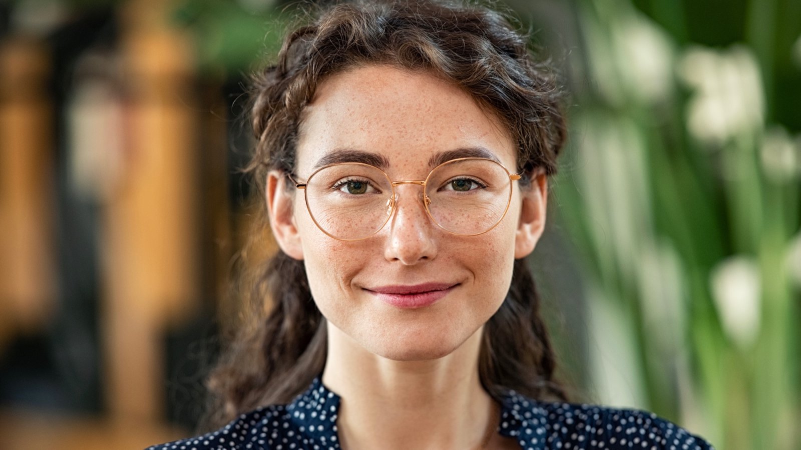 Lächelnde junge Frau mit Brille und Sommersprossen – Kundenstimme